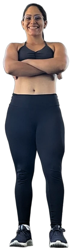 Gabriela hoje, na academia, de braços cruzados, sorrindo, de óculos e roupa de treino preta